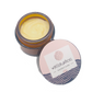 Geöffneter kleiner Glastiegel mit Füllung aus Handcreme, der Deckel ist im Vordergrund an den Tiegel gelehnt