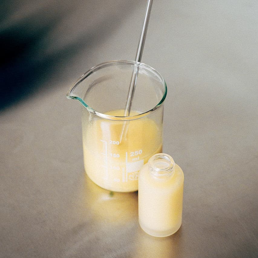 Laborglas und Glasfläschchen mit einem naturkosmetischen Pflegeprodukt im Labor von wasserundoel