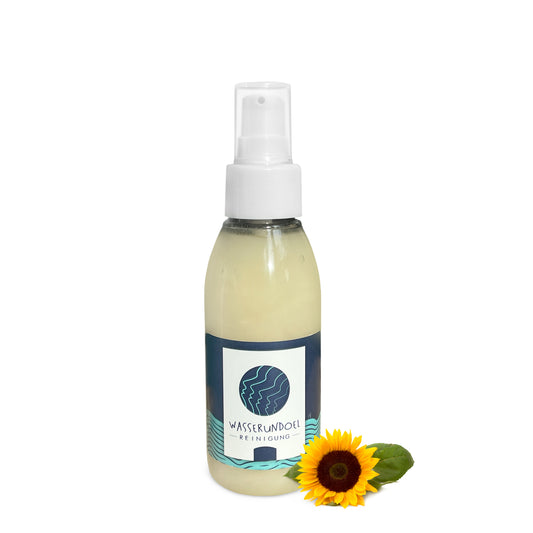 kleine Flasche mit Lotionpumpe mit dem Sonnenblumen-Waschgel von wasserundoel und kleiner Sonnenblume im Vordergrund